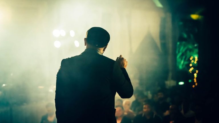 A speaker addressing an audience from the stage